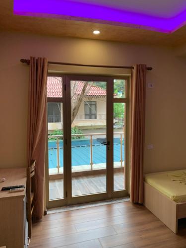 Habitación con una puerta corredera de cristal que conduce a la piscina. en Hotel Besa, en Shëngjin