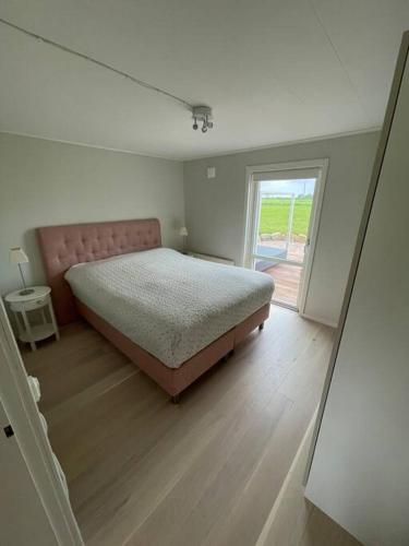 a bedroom with a large bed and a window at Modern house, views over the fields 5 min to beach in Halmstad