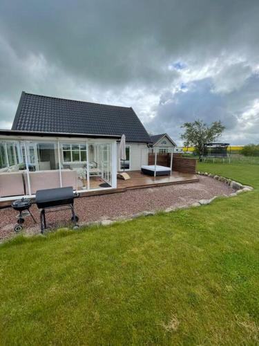 a house with a picnic table in front of a yard at Modern house, views over the fields 5 min to beach in Halmstad