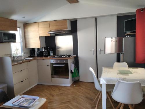 a kitchen with a table and a stove top oven at Mobil Home Ronce Les Bains in Ronce-les-Bains