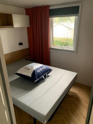 - un lit dans une chambre avec un oreiller dans l'établissement Mobil Home Ronce Les Bains, à Ronce-les-Bains