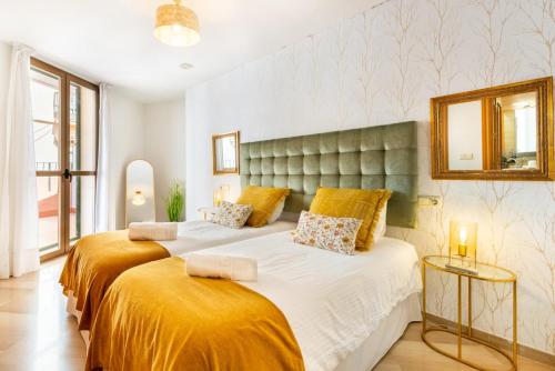 1 dormitorio con 2 camas y espejo en la pared en GRAN TERRAZA CON VISTAS A CALLE LARIOS en Málaga