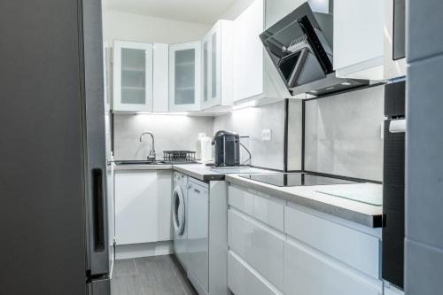 une cuisine blanche avec des armoires blanches et un évier dans l'établissement 2-Room Apartment with Terrace Sea View, à Cannes