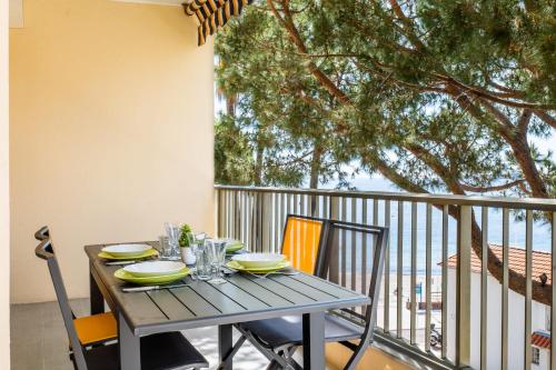 d'un balcon avec une table en bois et des chaises. dans l'établissement 2-Room Apartment with Terrace Sea View, à Cannes