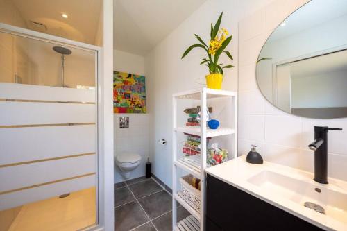 une salle de bain avec un lavabo, des toilettes et un miroir dans l'établissement cap belle étoile, à La Rochelle