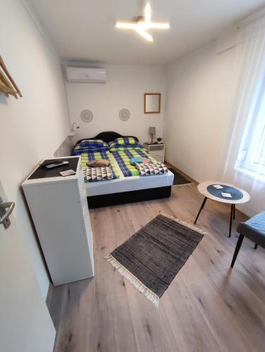 Habitación pequeña con cama y mesa en Apartman Valentin en Siófok