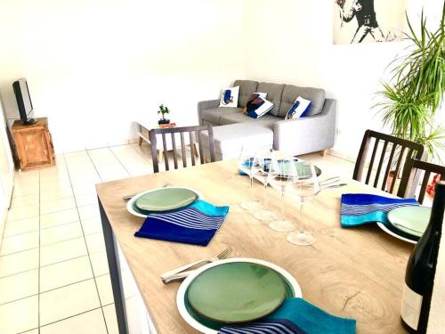 een houten tafel met blauwe en groene platen erop bij Confort plage piscine in Saint-Vincent-de-Tyrosse