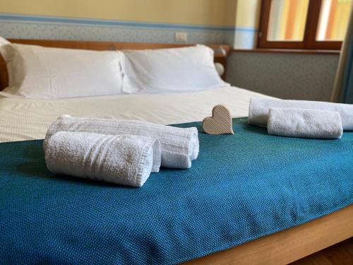 ein Bett mit zwei Handtüchern und einem Herz darauf in der Unterkunft Residenza d'Epoca Albergo Grimani in Ampezzo