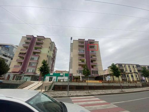 two tall buildings on the side of a city street at Cloud8 Apt with Castle View, 7km from the Beach in Lezhë