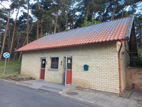 a small brick building with an orange roof at Jachta Varuna in Nida