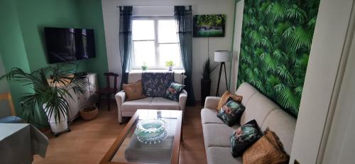 una sala de estar con un sofá y una mesa en Ferienwohnung Palmenwald, en Freudenstadt