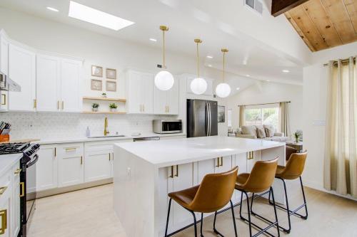 a kitchen with white cabinets and a kitchen island with chairs at 3892 Carmel Pearl home in Carmel