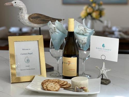 - une bouteille de vin et une assiette de biscuits et de verres à vin dans l'établissement 3892 Carmel Pearl home, à Carmel