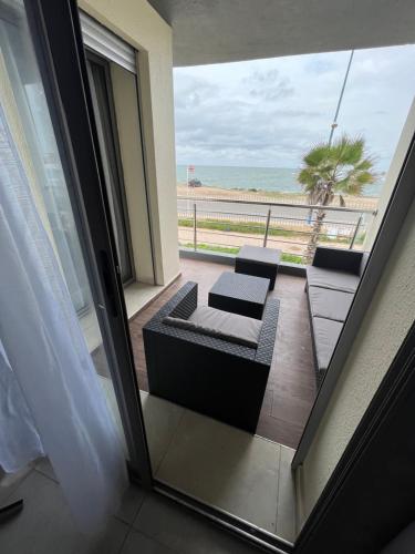 a room with a balcony with a view of the beach at Appartement El jadida Sidi Bouzid in Sidi Bouzid