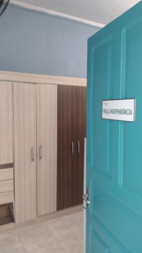 a blue door with a sign that reads pray incarcerated at Rolds Hostel in Santos