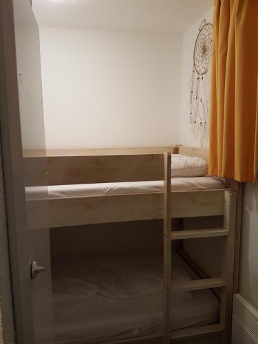 Ce lit superposé se trouve dans un dortoir doté d'un rideau orange. dans l'établissement Bel Apt 4 pers dernier étage balcon vue montagne, à Luz-Saint-Sauveur