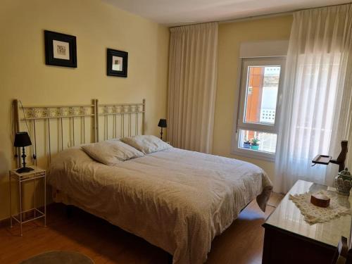 a bedroom with a bed and a window at Casa Roge in Luarca