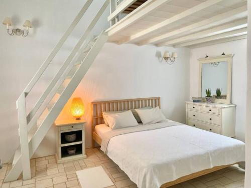 a white bedroom with a bed and a staircase at Villa Santa Maria-Sophia in Kampos Paros