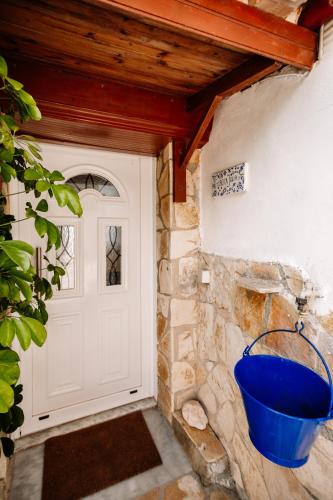 a blue bucket on a wall next to a door at Floreica Maisonneta By the Sea. in Skinária
