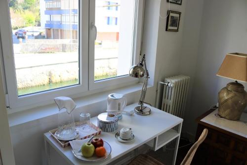 a white table with a plate of fruit and a window at Villa Isabela Bakio Rooms in Bakio