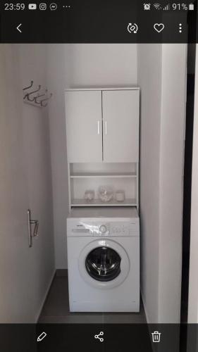 Waschmaschine und Trockner in einer Ecke eines Zimmers in der Unterkunft Kostas apartament in Kontokali