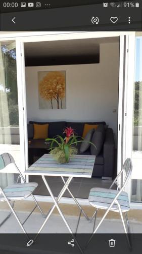 eine abgeschirmte Veranda mit einem Tisch und einer Couch in der Unterkunft Kostas apartament in Kontokali