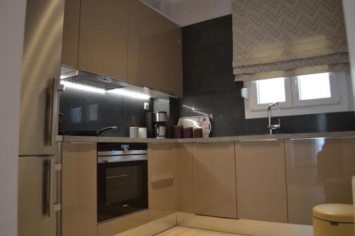 a kitchen with brown cabinets and a sink at Kalamaria brand new 2 bedroom apartment in Thessaloniki