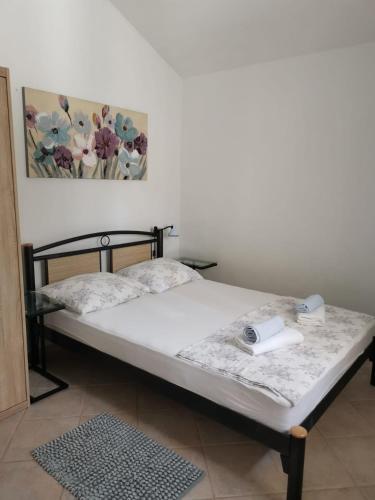 a bed in a room with a picture on the wall at Holiday home Penić in Rogoznica
