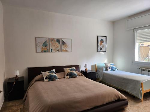 a bedroom with two beds and a window at Fausto&Deby Apartment in Oriago