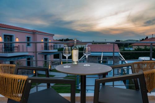 a table with two glasses of wine on a balcony at Nissos Apartments in Myrina