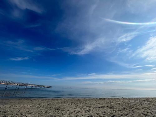 a beach with a pier in the water at La Villetta nel Delta in Mesola
