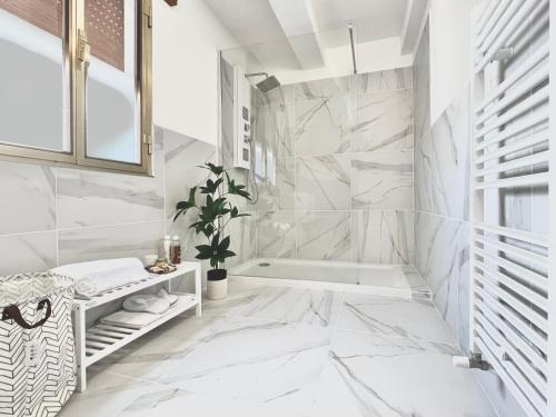 een badkamer met witte marmeren muren en een bad bij La Villetta nel Delta in Mesola