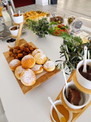 un montón de donuts en una tabla de cortar en una mesa en Hotel Villa Garden Ulcinj-Ulqin, en Ulcinj