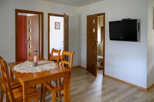 a kitchen and dining room with a table and a refrigerator at Domek na zacisznych obrzeżach Kazimierza Dolnego in Kazimierz Dolny