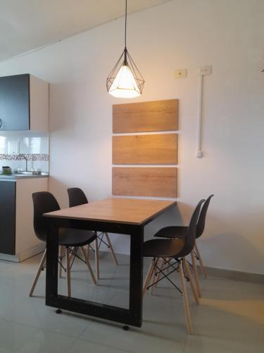a dining room table with black chairs and a light fixture at Casa Colibrí Hospedaje Manizales a 2 min del Cable y 1 min Zona G in Manizales