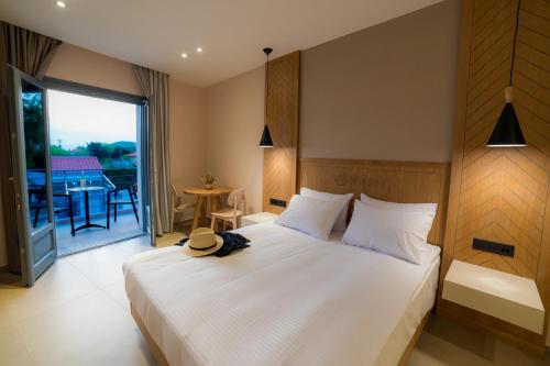 a bedroom with a bed with a hat on it at Nissos Apartments in Myrina