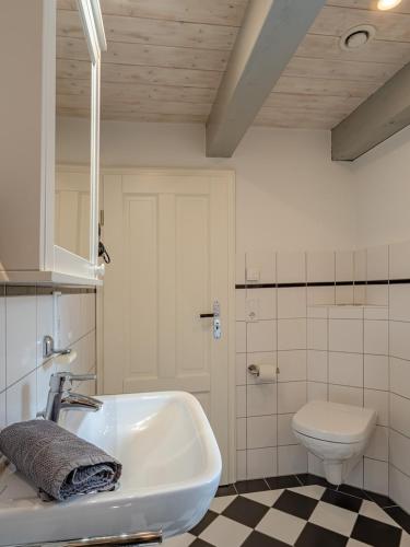 a bathroom with a white sink and a toilet at Westertilli 8 in Pellworm