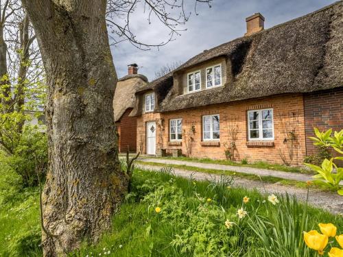 an old brick house with a thatched roof at Westertilli 8 in Pellworm