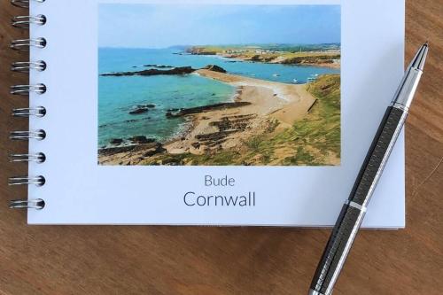 a notebook with a picture of a beach and a pen at Bosun's Bude in Bude