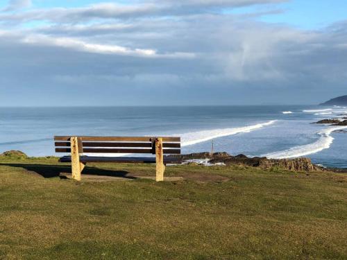 eine Bank auf einem Hügel mit Blick auf den Ozean in der Unterkunft Bosun's Bude in Bude