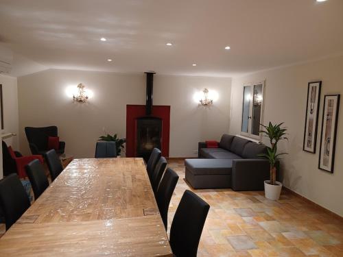 una sala de estar con una mesa larga y un sofá en Villa Comorebi Provence, en Entrecasteaux