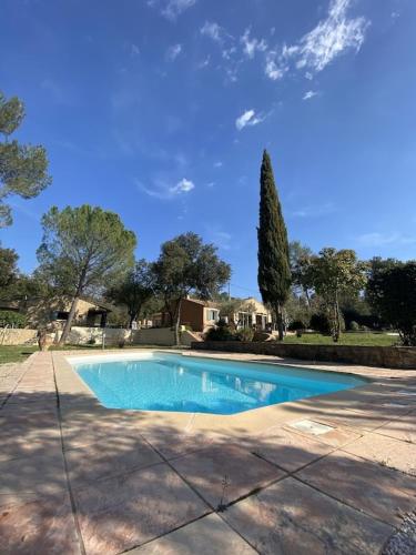 une grande piscine bleue dans une cour dans l'établissement Villa Comorebi Provence, à Entrecasteaux