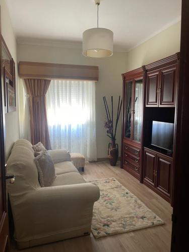 a living room with a couch and a television at Guest House “Casa da avó Tina” in Barreiro