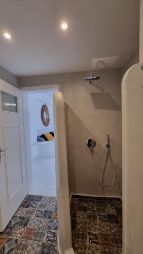 a bathroom with a shower with a hose at 3 Bedroom House included free car rental in Perissa