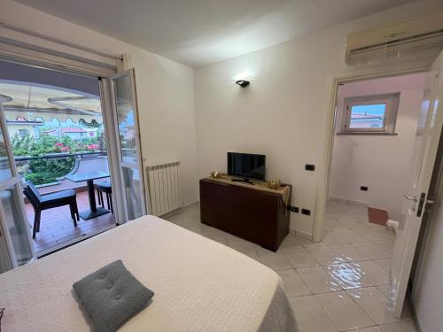 a bedroom with a bed and a television and a table at Villa I Giardini del Conero con ombrellone in spiaggia in Porto Recanati