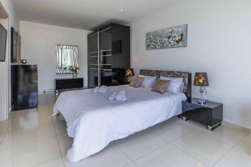 a bedroom with a large white bed with towels on it at Unique penthouse with private pool & sea view in St. Paul's Bay