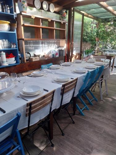 a long white table with chairs and plates on it at VILLA VILLACOLLE in Procchio
