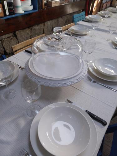 a table with white plates and glasses on it at VILLA VILLACOLLE in Procchio