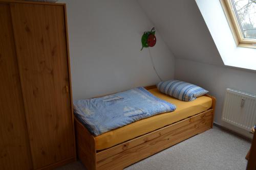 małe łóżko w małym pokoju z oknem w obiekcie Haus Simone w mieście Wyspa Poel
