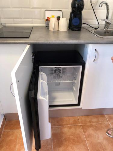 un lavavajillas abierto en una cocina bajo una barra en Loft 3 Nuevo,tercera planta sin ascensor,pequeño y coqueto,wifi y aire acondicionado, en La Línea de la Concepción